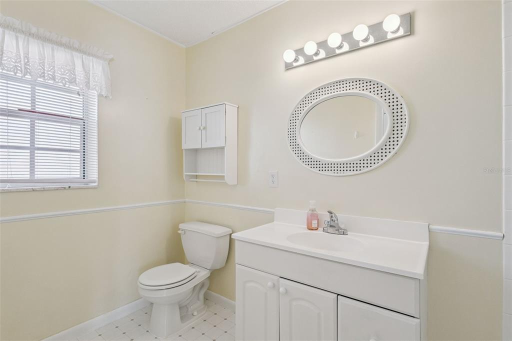 141 Northeast 50th Court Ocala, FL 34470 - Photo 26 of 42 a bathroom with a toilet a sink a mirror and a window