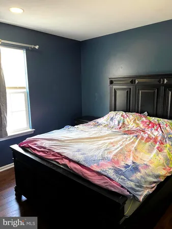 a bed sitting in a bedroom and with wooden floor