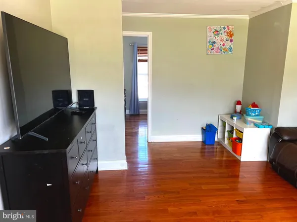 an empty room with wooden floor and cabinet