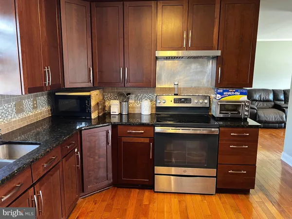 a kitchen with stainless steel appliances granite countertop a sink dishwasher stove and cabinets