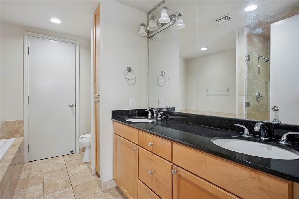 1505 Elm Street, Unit 603 Dallas, TX 75201 - Photo 12 of 36 a bathroom with a granite countertop sink and a mirror