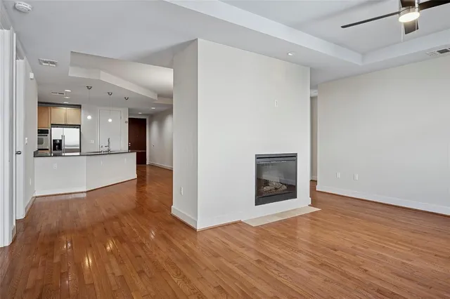 a view of a big room with wooden floor and a kitchen