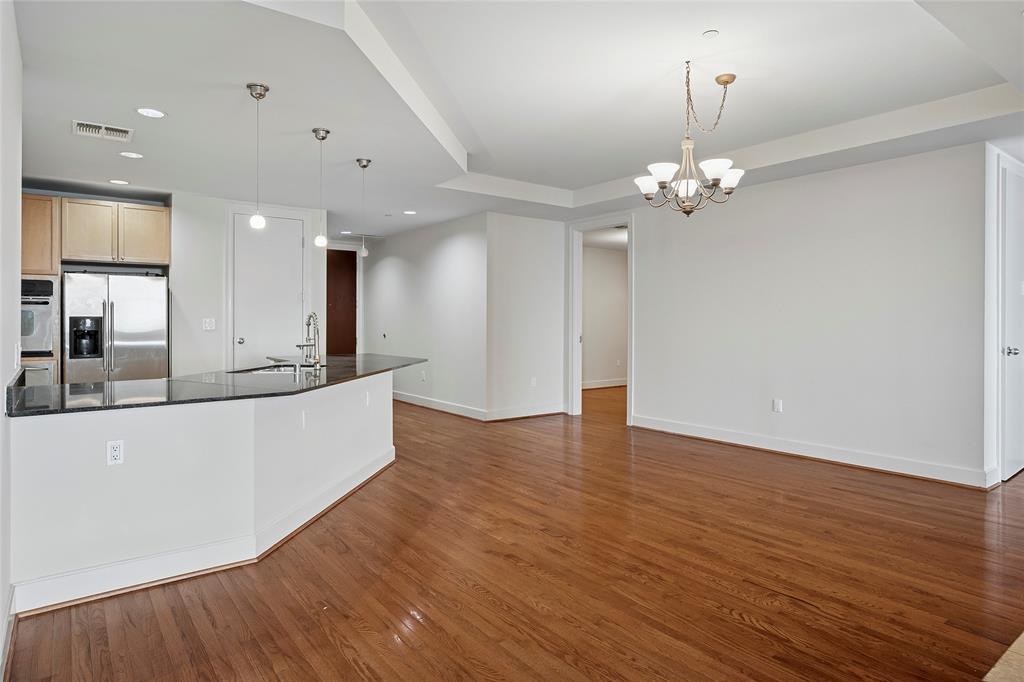 1505 Elm Street, Unit 603 Dallas, TX 75201 - Photo 5 of 36 a view of a kitchen with kitchen island stainless steel appliances wooden floor and a large window