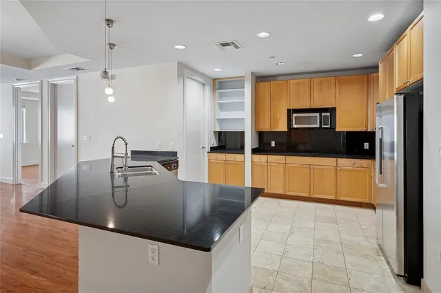 a large kitchen with stainless steel appliances a large counter top