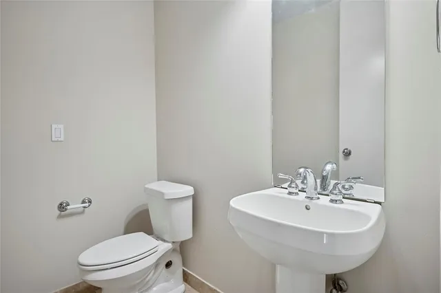 a bathroom with a sink a toilet and mirror