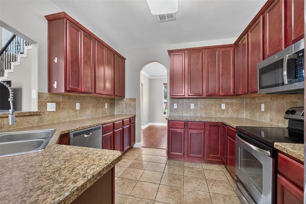 517 Austin Acre Road Sulphur Springs, TX 75482 - Photo 12 of 23 a kitchen with stainless steel appliances granite countertop wooden cabinets a stove top oven a sink and dishwasher