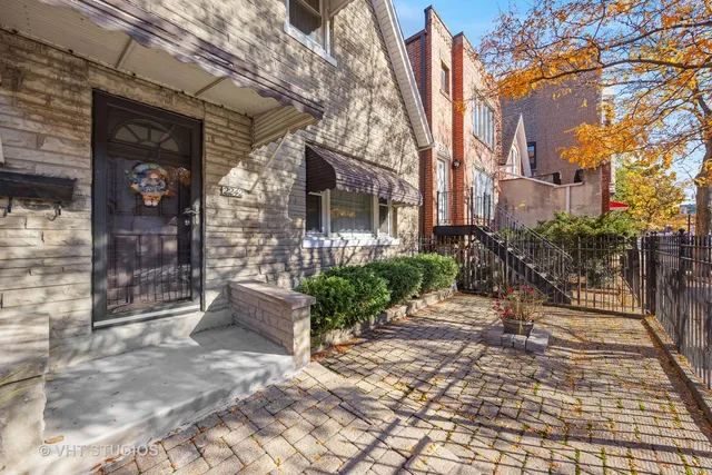a view of a brick house with a bench in patio