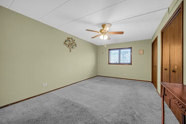 an empty room with a window and a ceiling fan