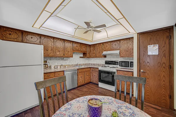 a kitchen with stainless steel appliances granite countertop a refrigerator a stove top oven a sink and dishwasher