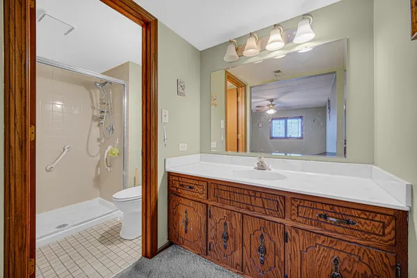 a bathroom with a granite countertop sink mirror and a bathtub