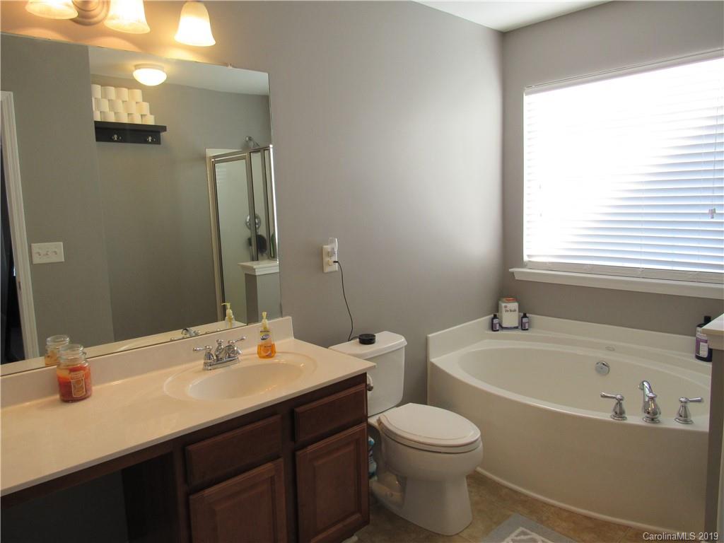 4406 Red Hook Road Monroe, NC 28110 - Photo 12 of 15 a bathroom with a bathtub shower sink vanity mirror and toilet