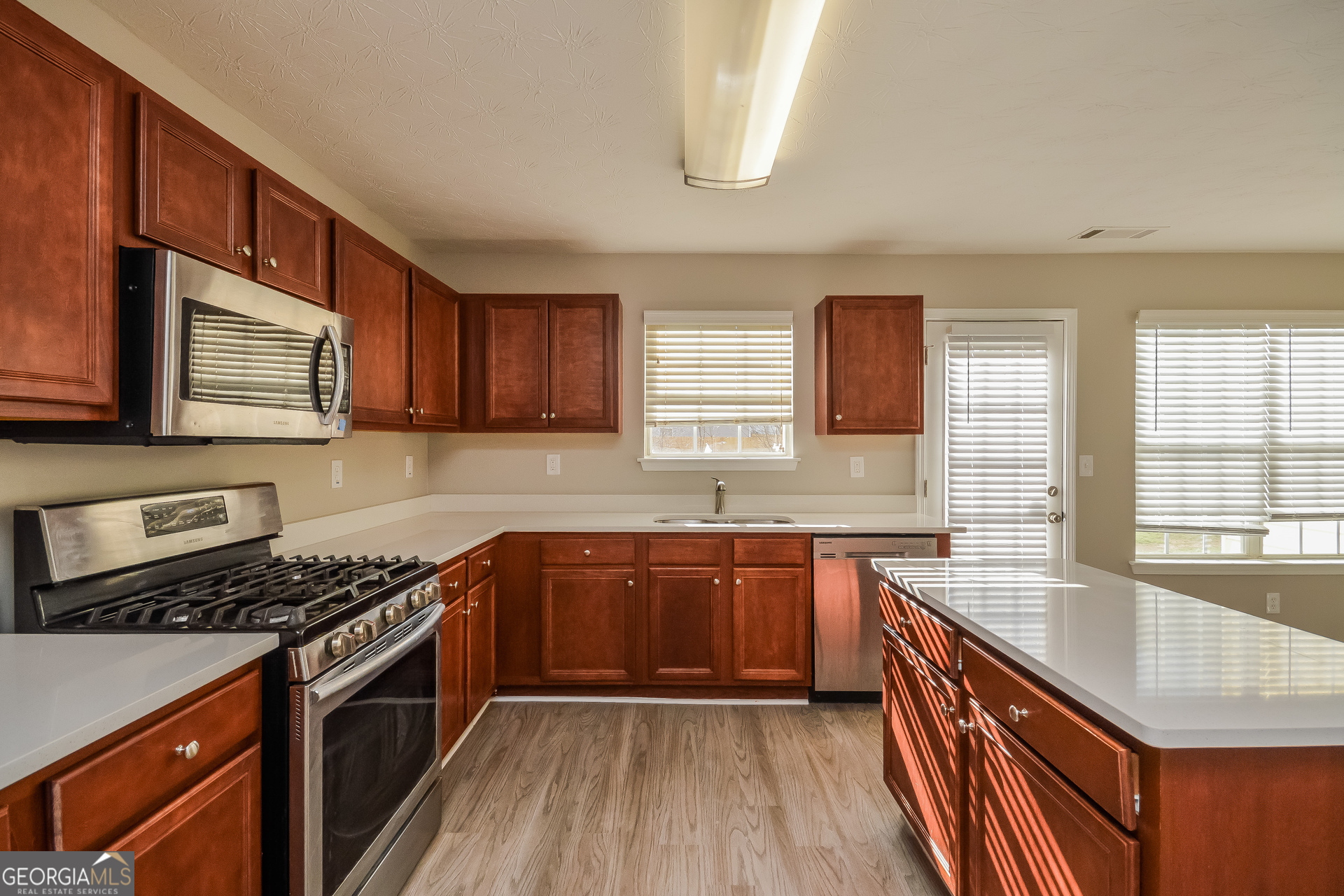 90 Emerson Trail Covington, GA 30016 - Photo 7 of 17 a kitchen with stainless steel appliances granite countertop wooden cabinets stove top oven and sink