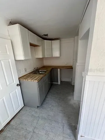 a kitchen with a sink a stove top oven and cabinets