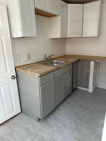 a kitchen with cabinets stove and sink