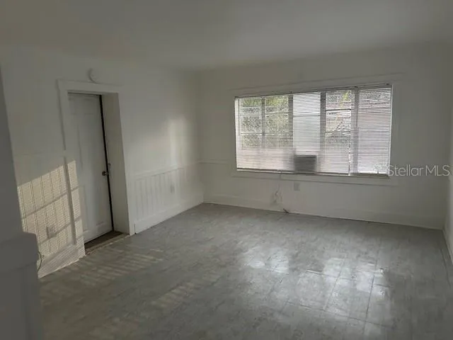 an empty room with a fireplace and windows
