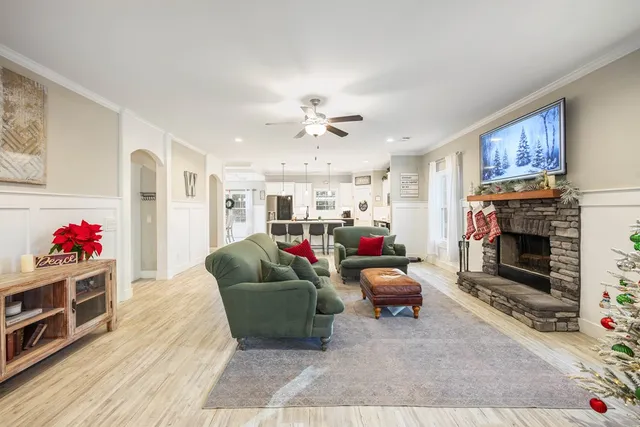 a living room with furniture a wooden floor and white walls