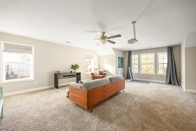 a living room with furniture fireplace and a large window