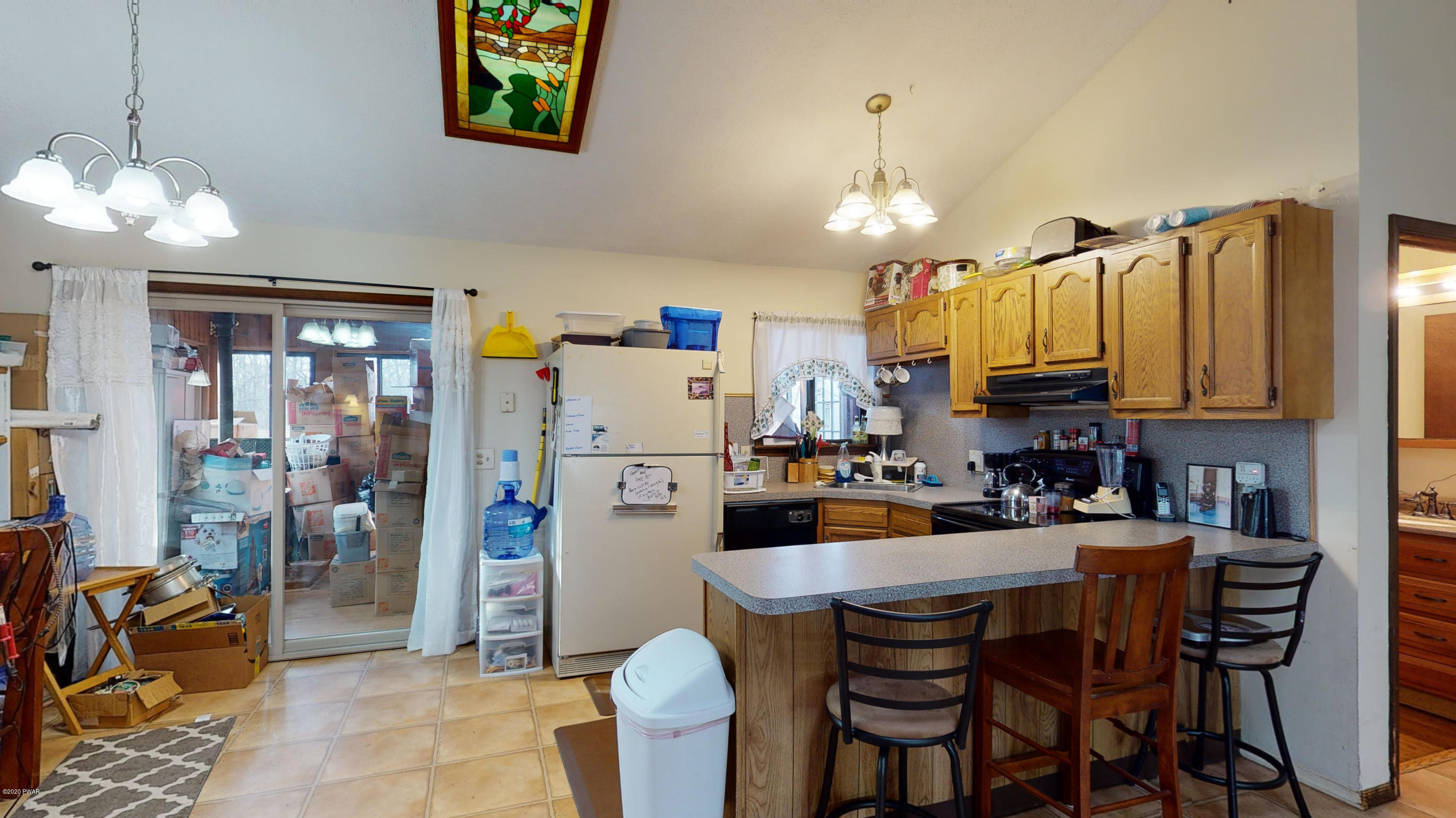 130 Maple Ridge Road Milford, PA 18337 - Photo 22 of 44 a kitchen with stainless steel appliances granite countertop a refrigerator a sink dishwasher a dining table and chairs with wooden floor
