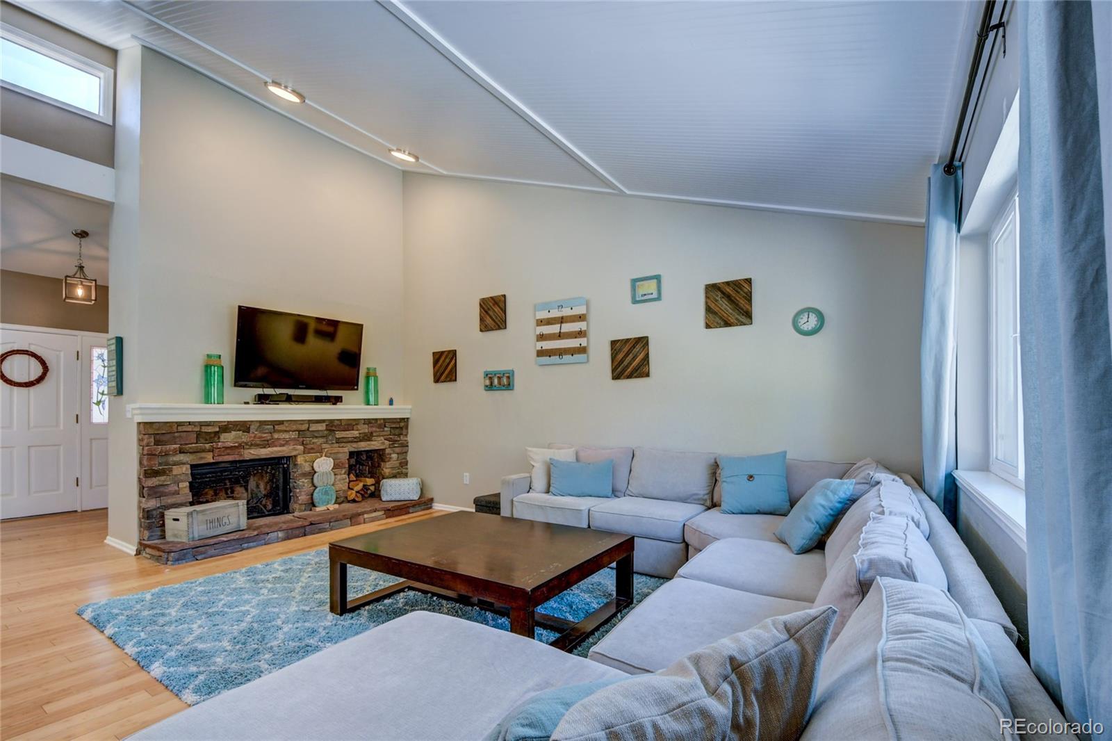 6359 Powell Road Parker, CO 80134 - Photo 15 of 38 a living room with furniture a flat screen tv and a fireplace