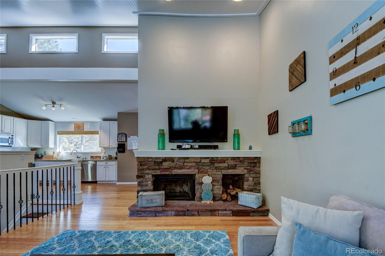 6359 Powell Road Parker, CO 80134 - Photo 17 of 38 a living room with furniture a flat screen tv and a fireplace