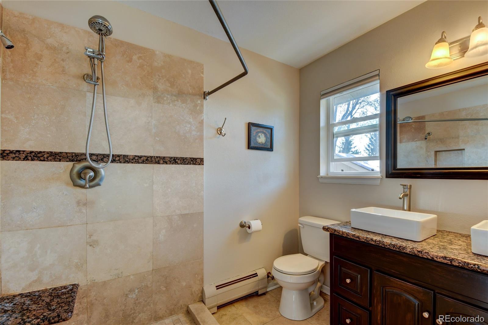 6359 Powell Road Parker, CO 80134 - Photo 21 of 38 a bathroom with a granite countertop sink toilet and shower