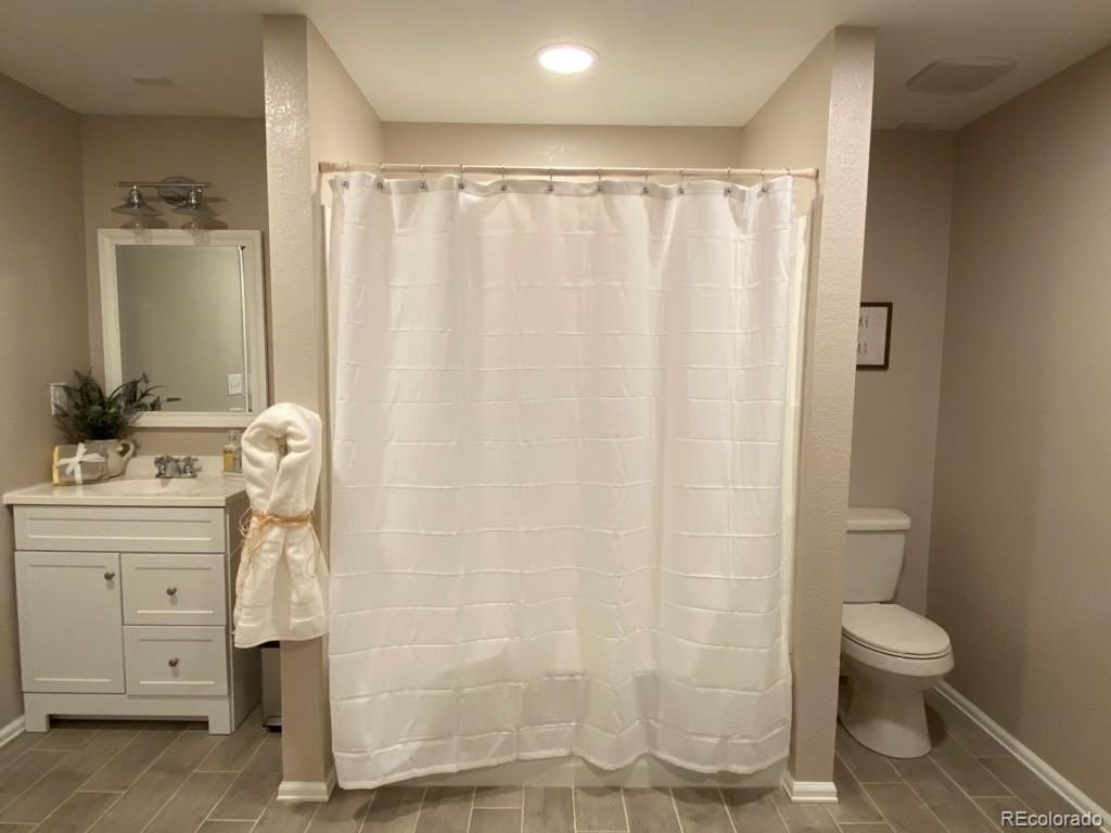 6359 Powell Road Parker, CO 80134 - Photo 28 of 38 a bathroom with a shower curtain and sink