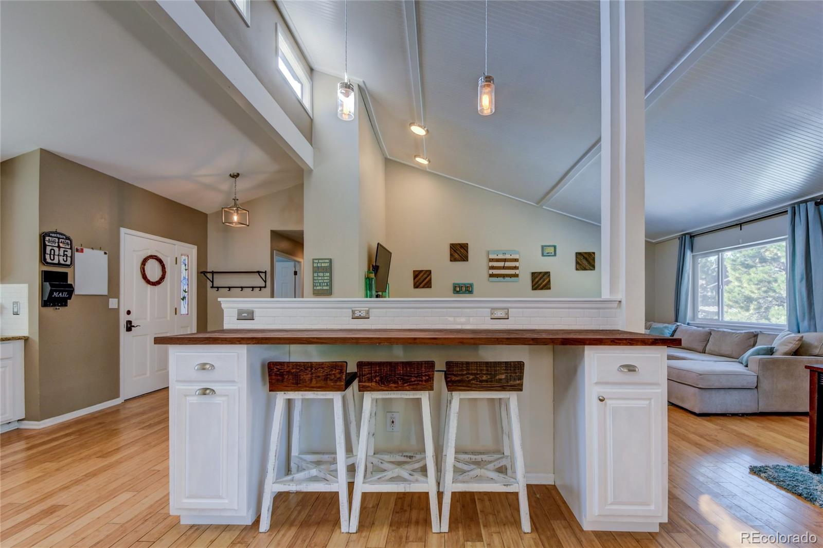 6359 Powell Road Parker, CO 80134 - Photo 9 of 38 a kitchen with a table chairs refrigerator and wooden floor