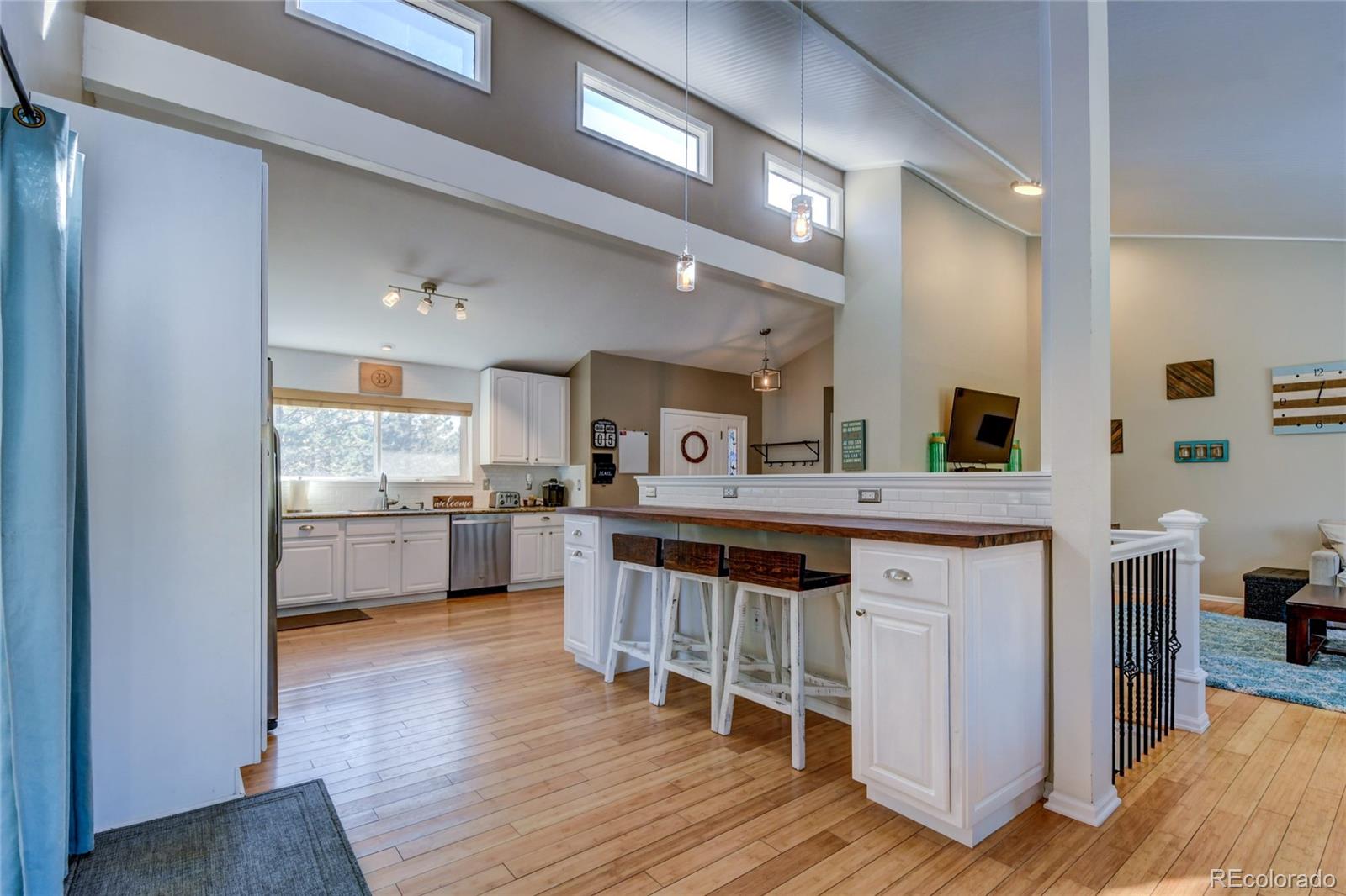 6359 Powell Road Parker, CO 80134 - Photo 10 of 38 a kitchen with stainless steel appliances kitchen island granite countertop a sink cabinets and wooden floor