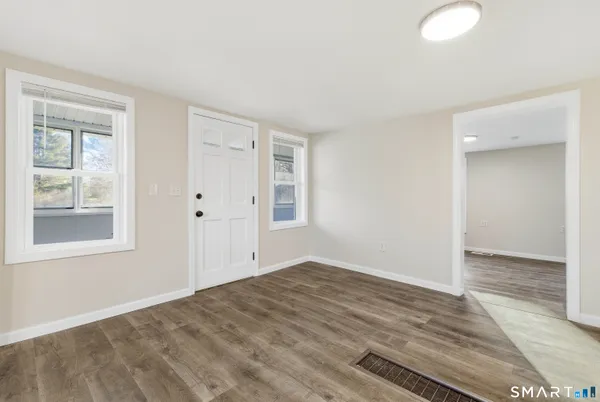 a view of empty room with wooden floor and fan