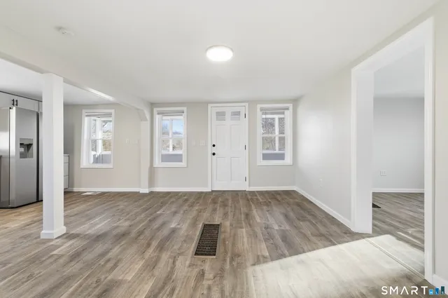 an empty room with wooden floor and windows
