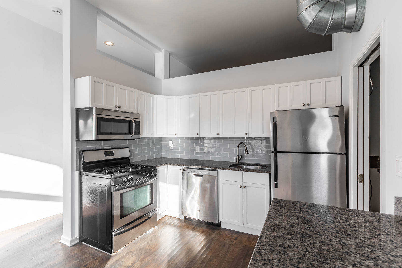 1133 West Madison Street, Unit 2R Chicago, IL 60607 - Photo 4 of 15 a kitchen with stainless steel appliances a refrigerator stove and microwave
