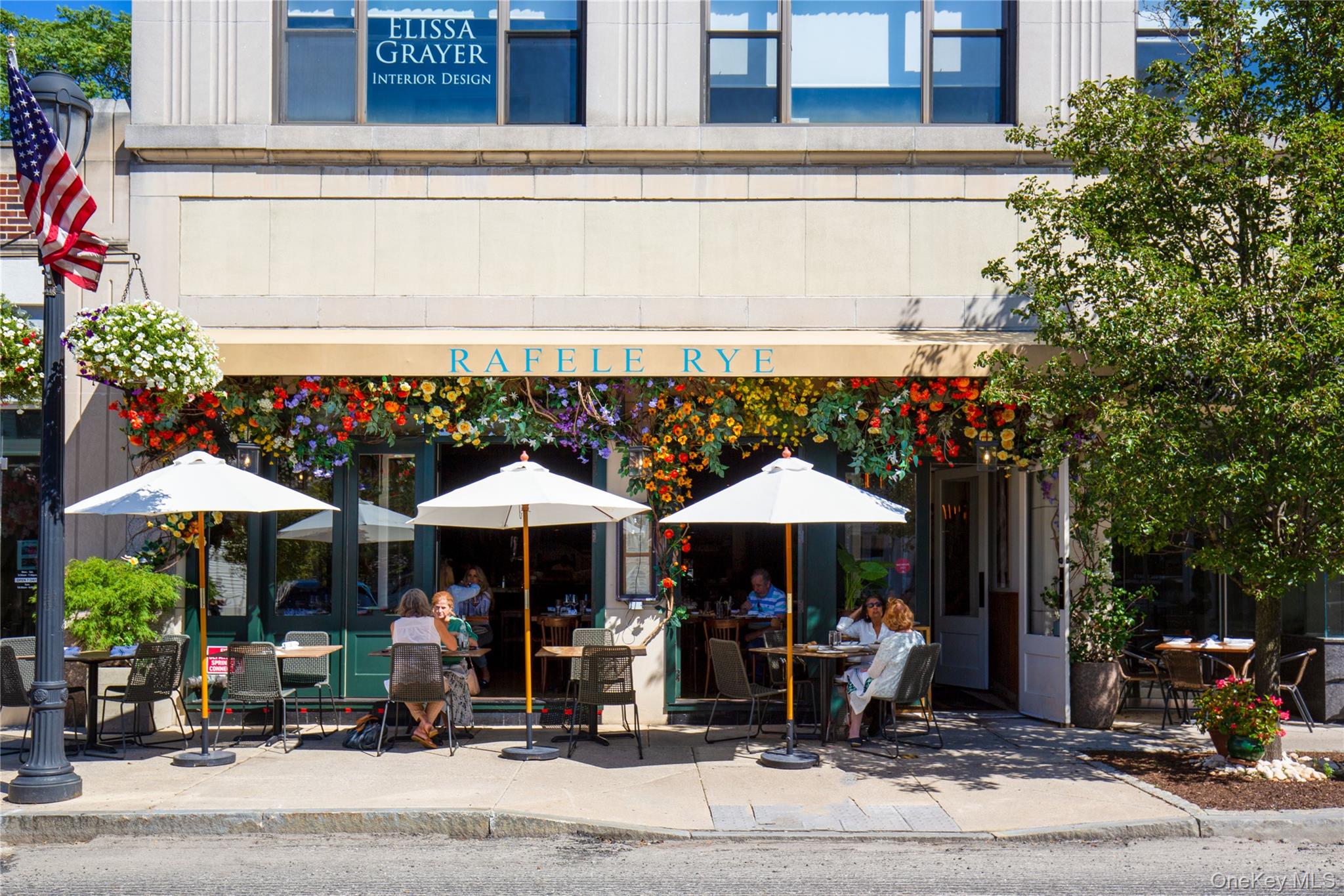 28 Everett Street Rye, NY 10580 - Photo 18 of 21 a table and chairs under an umbrella in front of building