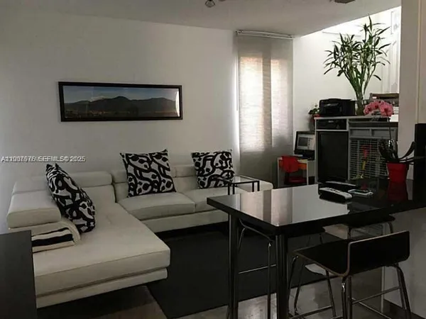 a living room with furniture a table and a potted plant