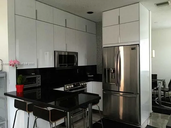 a kitchen with a refrigerator and a stove top oven