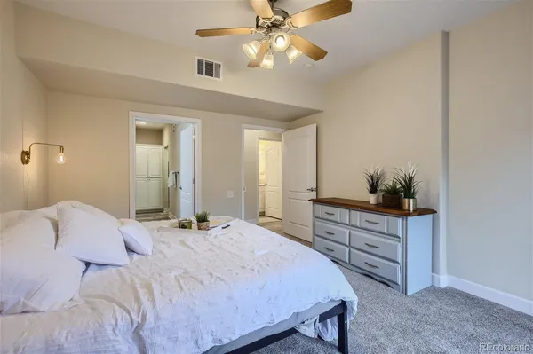 a bedroom with a bed and a chandelier fan