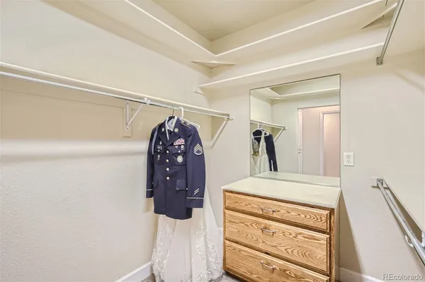 a view of walk in closet with clothes