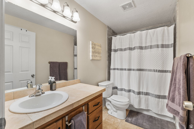 6208 West Bull River Road Highland, UT 84003 - Photo 56 of 90 Full bathroom featuring an integrated sink set in a tiled vanity with wood-finish cabinetry, a chrome faucet, and overhead vanity lighting