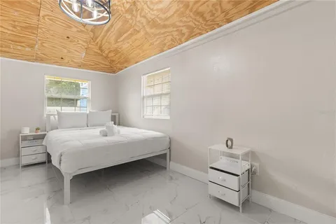 a bedroom with a bed and a chandelier