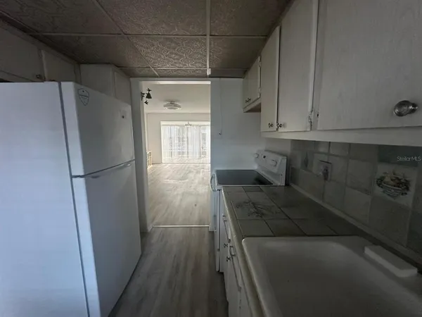 a kitchen with a refrigerator and cabinets
