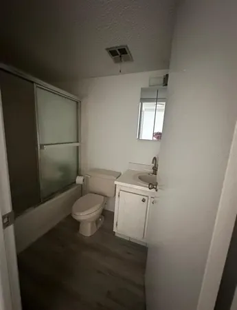 a bathroom with a toilet a sink and mirror