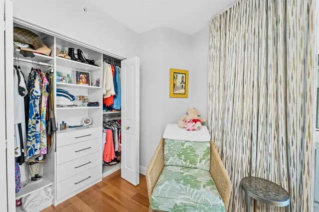 a view of walk in closet with clothes and shoes