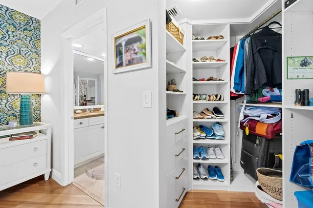 a view of walk in closet with clothes and shoes