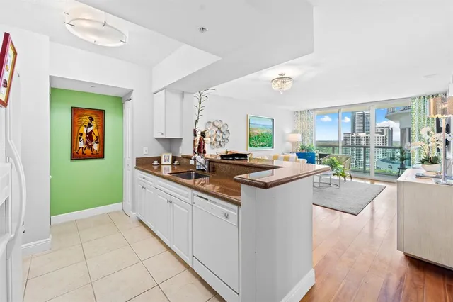 a kitchen with kitchen island granite countertop a sink and a stove top oven