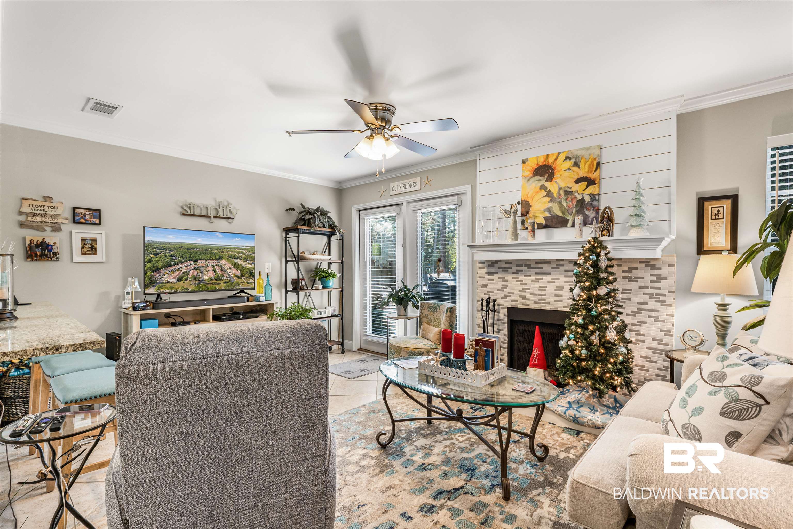 1517 Regency Road, Unit 68 Gulf Shores, AL 36542 - Photo 10 of 43 Living room featuring a tile fireplace, ceiling fan, and crown molding