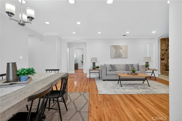 a living room with furniture wooden floor and a chandelier