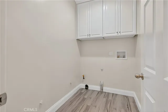 a view of storage and utility room with wooden floor