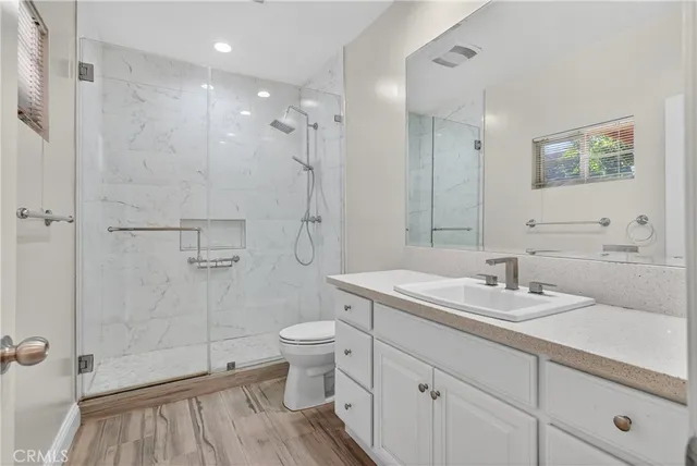 a bathroom with a sink a toilet and shower