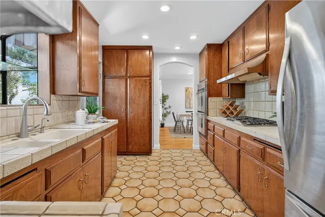 a kitchen with stainless steel appliances a sink stove and refrigerator
