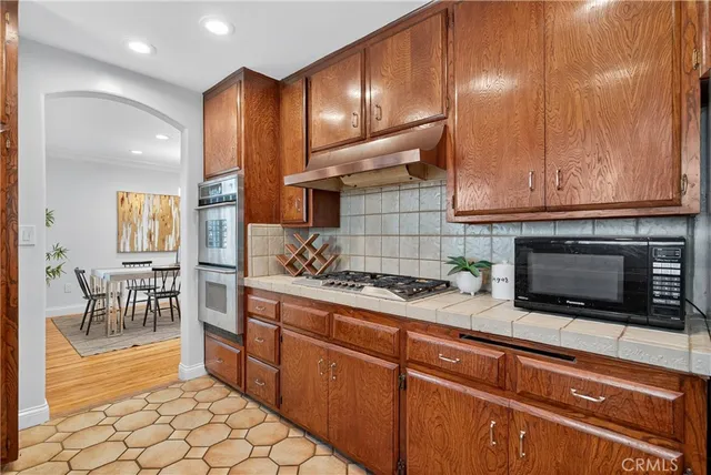 a kitchen with stainless steel appliances wooden cabinets and a stove top oven