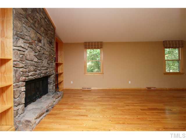 6248 Rushingbrook Drive Raleigh, NC 27612 - Photo 7 of 25 a view of an empty room with a fireplace and a window
